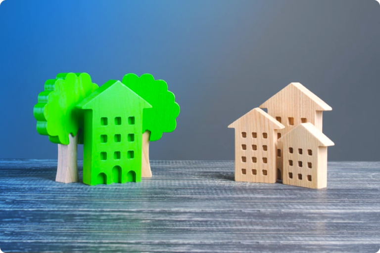 Photo de maquettes de maison en bois. A droite, elles sont vertes et à gauche beiges