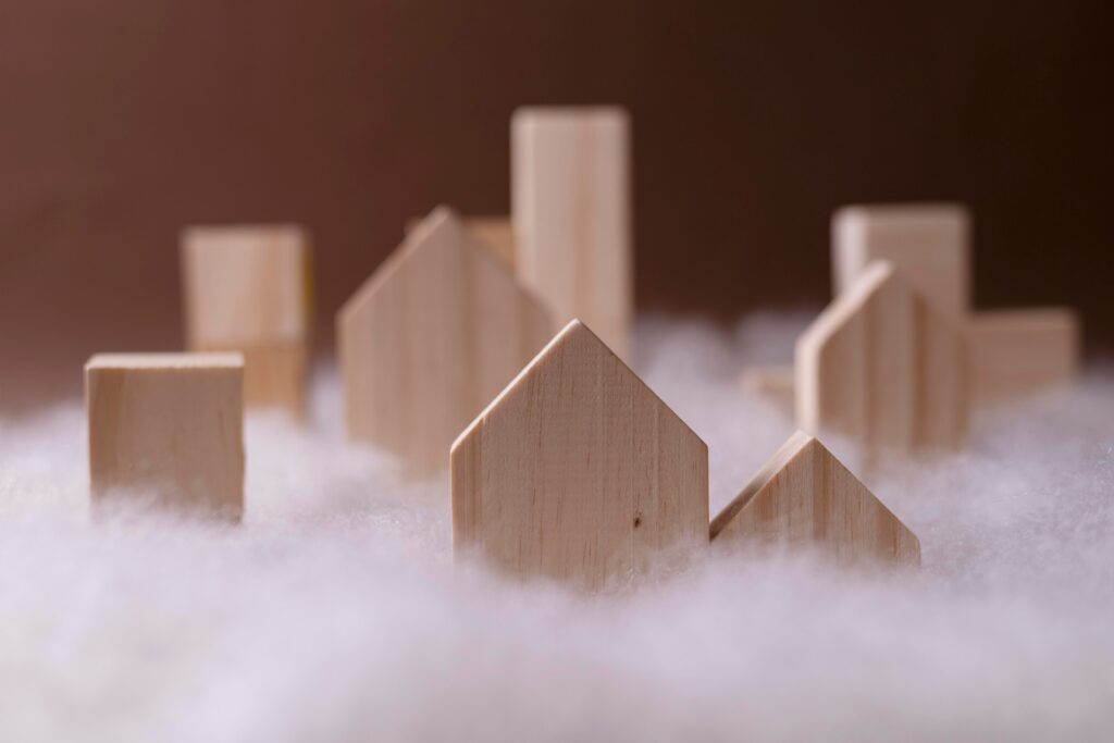 Photo de pièces de bois représentant des maisons et immeubles, entourés de coton