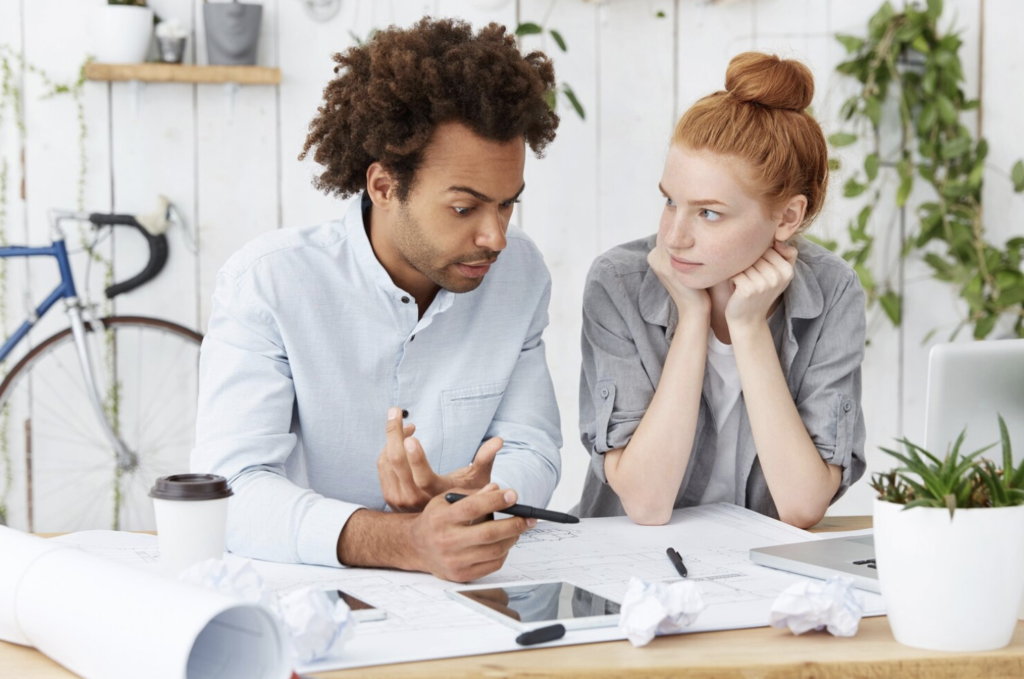 Photo d'un couple discutant assis devant une table avec des notes
