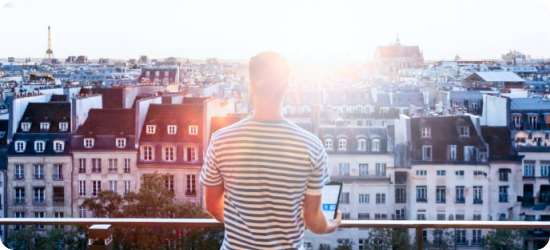 Un homme regarde le coucher de soleil sur les bâtiment