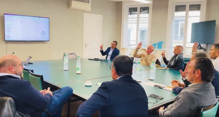 Tablée de personnes levant la main