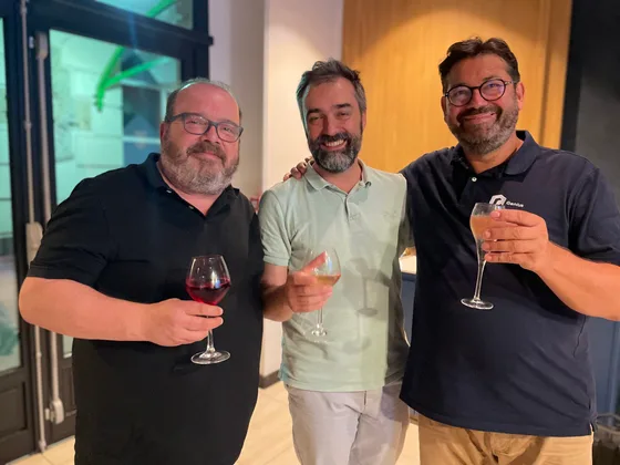 Trois participants du Genius Club Lille posent en souriant, un verre à la main