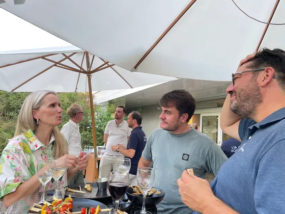 Participants du Genius Club Nantes en discussion sous un parasol pendant le cocktail en extérieur